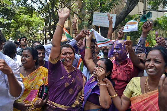 Congress party supporters celebrate outside a counting station after hearing news of the party leading in the recently held state elections in Bangalore.