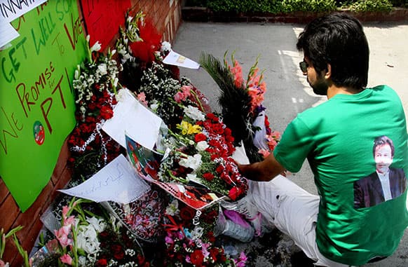 A Pakistani supporter of Imran Khan, Pakistan`s star cricketer-turn-politician, lays bouquet outside the hospital where Khan is admitted in Lahore.