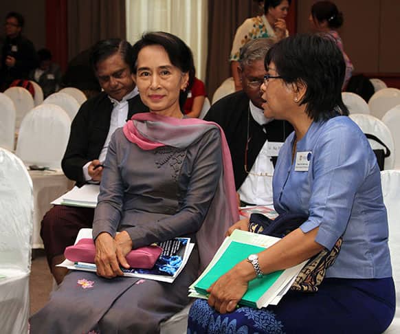 Myanmar opposition leader Aung San Suu Kyi, left, takes a seat to attend the Myanmar Constitutional Democracy Workshop at Micasa Hotel in Yangon.