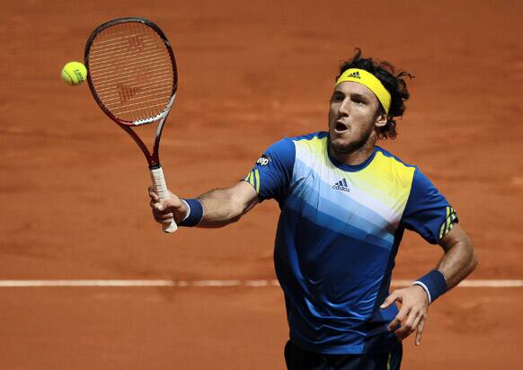 Juan Monaco from Argentina returns the ball to Janko Tipsarevic from Serbia during the Madrid Open tennis tournament, in Madrid.