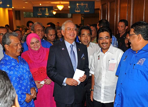 Malaysian Prime Minister Najib Razak, center, smiles as he arrives during a meeting with his ruling National Front coalition`s members of parliament in Kuala Lumpur, Malaysia.