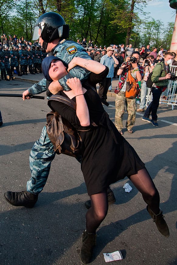 A Russian police officer detains protester Alexandra Dukhanina during an opposition rally in Moscow.