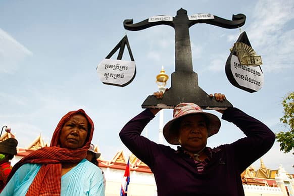 A protester from Boeung Kak lake holds a cutout of a scale symbolizing justice as she joins other villagers, who were allegedly evicted from their homes without adequate compensation, during a rally in front of the Justice Ministry in Phnom Penh, Cambodia.