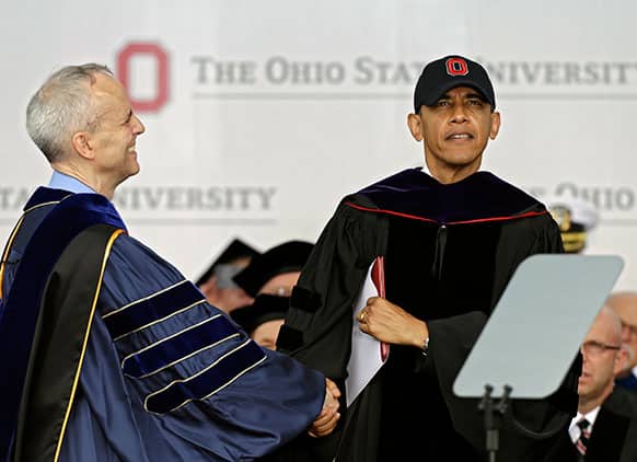 President Barack Obama is congratulated by David Horn, left, after receiving an honorary doctor of law degree at Ohio State University`s spring commencement in Columbus, Ohio.