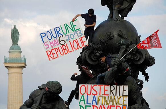 Demonstrators stand on a statue which represents Marianne, symbol of the state and values of France, during a rally to protest the austerity plan of French President Francois Hollande in Paris.