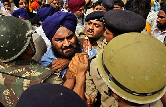 Police try to stop a Sikh protester as he protests the acquittal of ruling Congress party leader Sajjan Kumar of charges that he incited mobs to kill Sikhs during the country`s 1984 anti-Sikh riots in New Delhi.