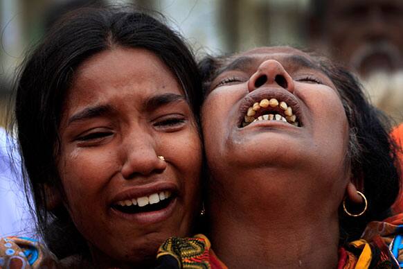 A woman is comforted as she grieves after identifying the body of her daughter, a victim of the garment factory collapse, Sunday, May 5, 2013 in Savar, near Dhaka.