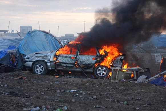 A vehicle burning after a raid by Iraqi security forces on a Sunni protest camp in a public square that killed scores in Hawija, Iraq.