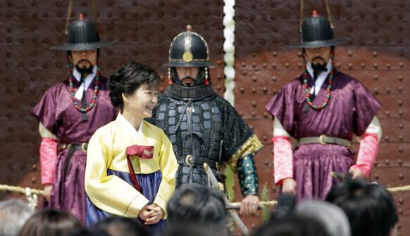 South Korean President Park Geun-hye wearing traditional dress stands near the participants wearing traditional military uniforms during Sungnyemun Gate restoration ceremony in Seoul, South Korea.