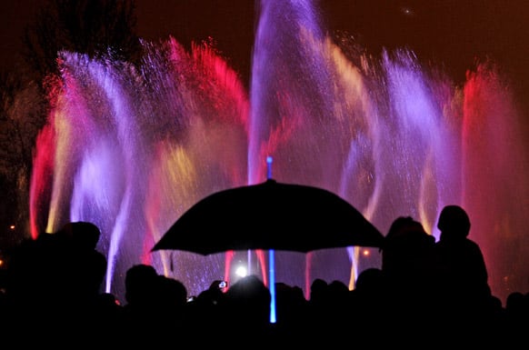 People watch a fountain light show in Warsaw, Poland. Thousands of spectators came to a Old Town park to see the first show in this year`s season.