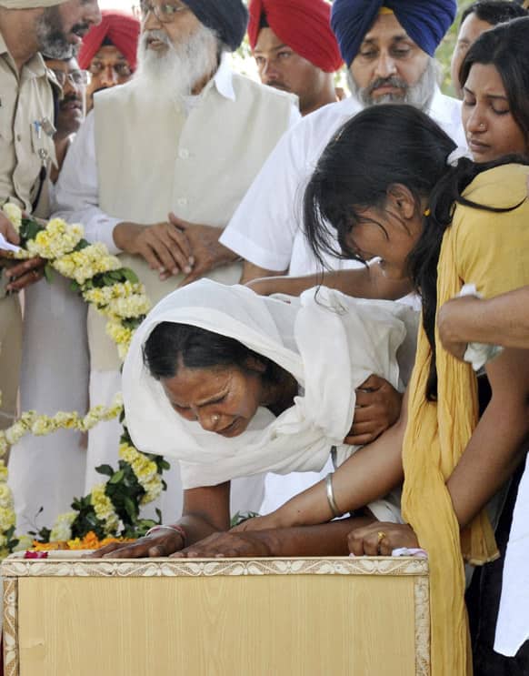 Sukhpreet Kaur, wife of Sarabjit Singh cries over his coffin during his funeral at Bhikhiwind.