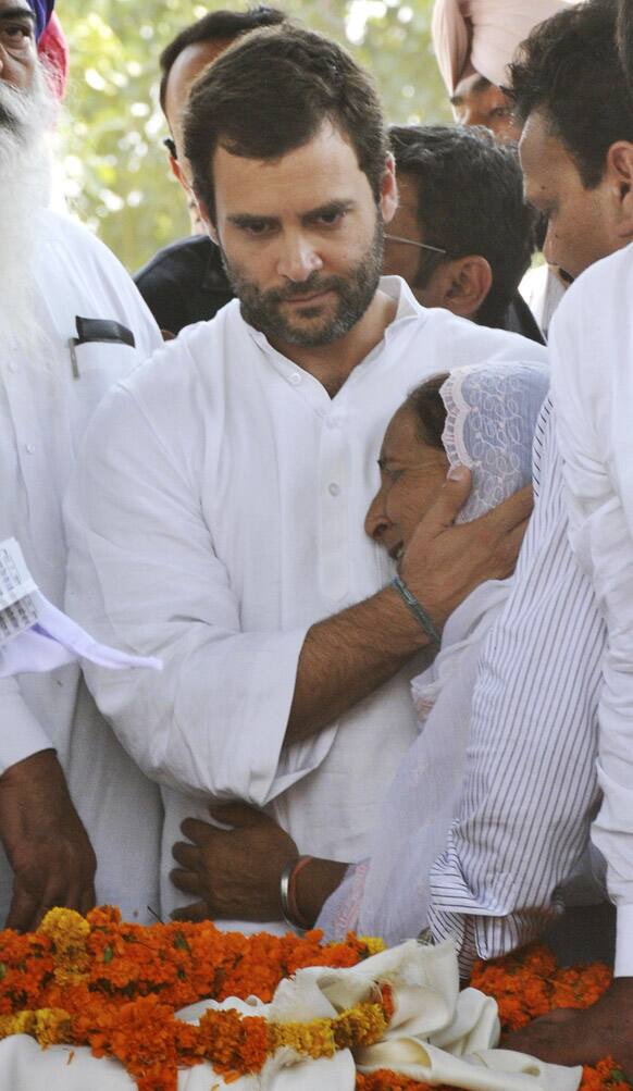 Congress party leader Rahul Gandhi consoles Dalbir Kaur near the body of her brother Sarabjit Singh at Bhikhiwind.