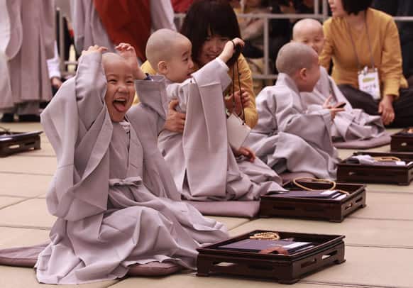 A boy reacts after he has his head shaven during a ceremony ahead of Buddha`s upcoming birthday on May 17 at the Jogye temple in Seoul, South Korea. Ten children entered the temple to have an experience with life in temple monks which lasts for 16 days.