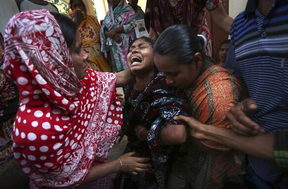 A woman is comforted by family members and others after she identified the body of her relative recovered from the rubble of the garment factory building which collapsed last week, in Savar, near Dhaka, Bangladesh.