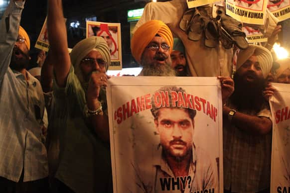 Sikhs shout slogans against Pakistan as they display photographs of Sarabjit Singh during a protest in Kolkata.