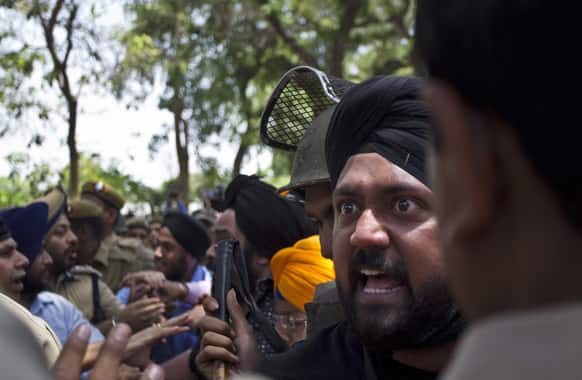 A Sikh shouts at police who try to detain him during a protest outside the residence of Sonia Gandhi after an Indian court Tuesday acquitted Congress party leader of charges that he incited mobs to kill Sikhs during the country`s 1984 anti-Sikh riots in New Delhi.