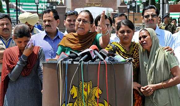 Dalbir Kaur, sister of Sarabjit Singh, an Indian spy on death row in Pakistan, addresses the media as Singh’s wife Sukhpreet Kaur, right, and daughters Poonam, left, and Swapandeep, second from right, stand beside her after entering Indian soil at the India-Pakistan border area of Wagah, India.