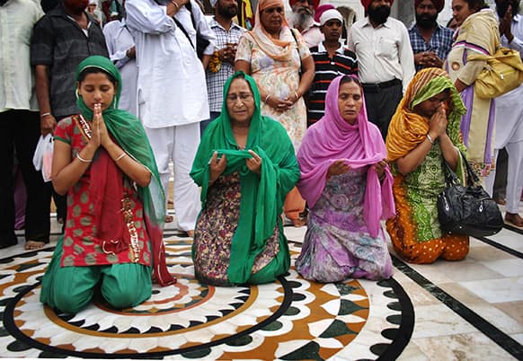 Wife Sukhpreet Kaur, second right, sister Dalbir Kaur, second left, and daughters Poonam, left, and Swapandeep of Sarabjit Singh, an Indian spy on death row in Pakistan offer prayers at the Golden Temple before crossing the border to Pakistan, in Amritsar, India.