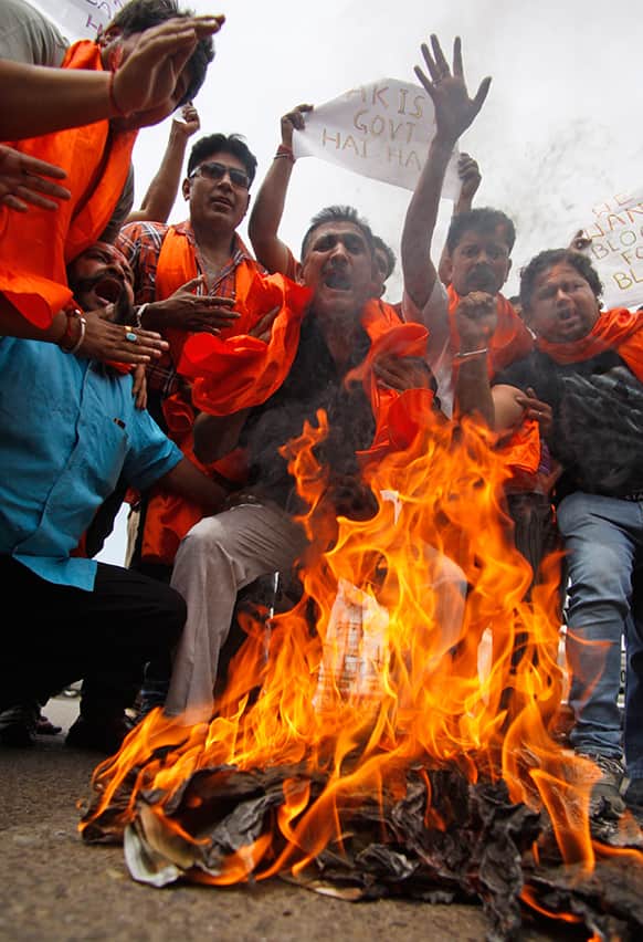 Activists of right-winged Rashtrawadi Shiv Sena shout slogans against the Pakistan government and burn their national flag during a protest against an attack on an Indian prisoner in a Lahore prison, in Jammu, India.