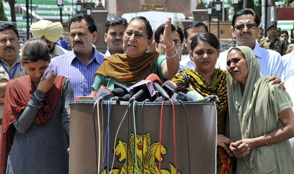 Dalbir Kaur, sister of Sarabjit Singh, addresses the media as Singh’s wife Sukhpreet Kaur and daughters stand beside her after entering Indian soil at the India-Pakistan border area of Wagah, India.
