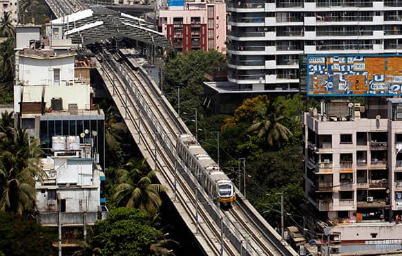 A Mumbai Metro train passes through a residential area during its first official safety trial run in Mumbai.