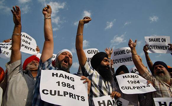 Indian Sikhs hold placards and shout slogans as they protest after an Indian court Tuesday acquitted a ruling Congress party leader of charges that he incited mobs to kill Sikhs during the country`s 1984 anti-Sikh riots in Jammu.