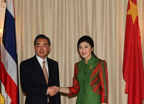 Chinese Foreign Minister Wang Yi, left, shakes hands with Thai Prime Minister Yingluck Shinawatra at Government House in Bangkok, Thailand.