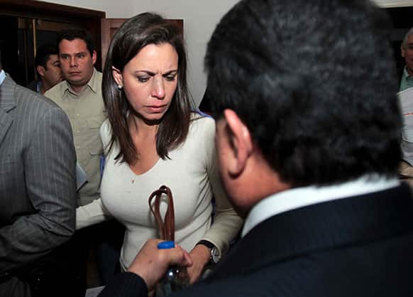 Opposition lawmaker Maria Corina Machado is escorted by party members as she arrives to her political party`s headquarters before a press conference in Caracas, Venezuela.