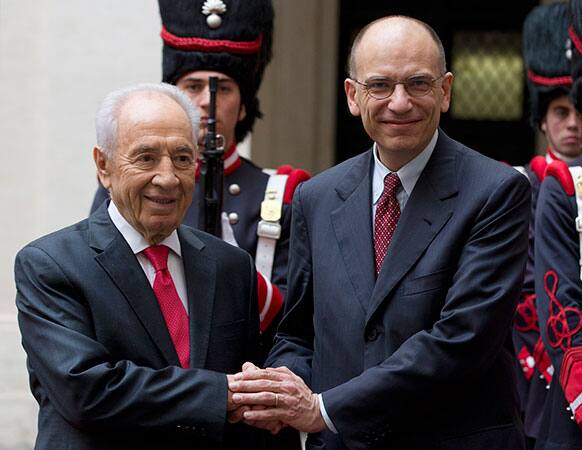 Italian Premier Enrico Letta, right, shakes hands with Israel`s President Shimon Peres as they meet in Rome`s Chigi government palace.