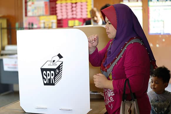 A Malaysian voter casts her ballot during the early voting for the general election in Kuala Lumpur.