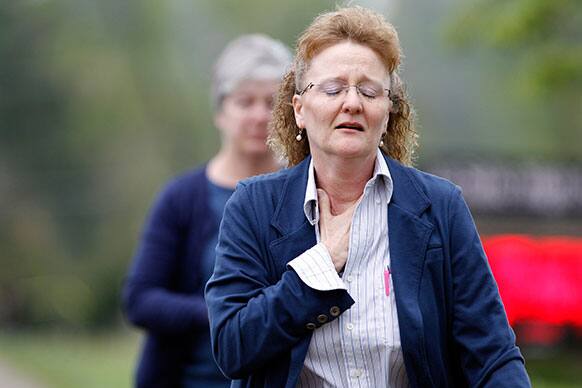 An unidentified woman walks toward La Salle High School, in Cincinnati, where a student pulled out a gun and shot himself in a classroom.