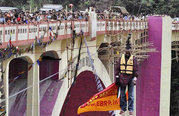 People watch Sailendra Nath Roy suspended from a zip wire attached to his ponytail in an attempt to cross Teesta river. Roy who was named a Guinness World Record holder in 2011 for travelling the farthest distance on a zip wire using hair died during the stunt Sunday when he suffered a heart attack.