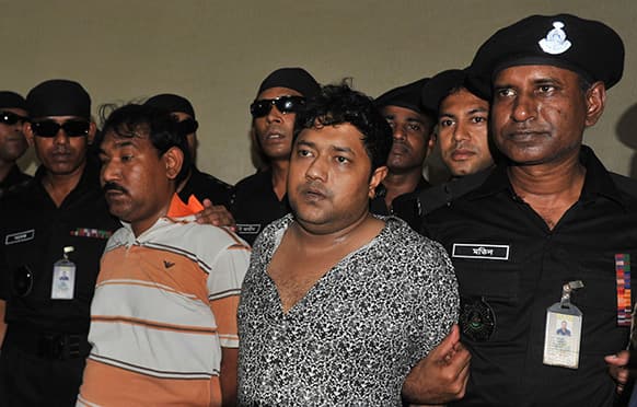 Mohammed Sohel Rana, centre right, the fugitive owner of an illegally-constructed building that collapsed last week in Bangladesh, killing some 377 people, is paraded by Rapid Action Battalion commandoes for the media along with an unidentified alleged accomplice, seen at left, in Dhaka.