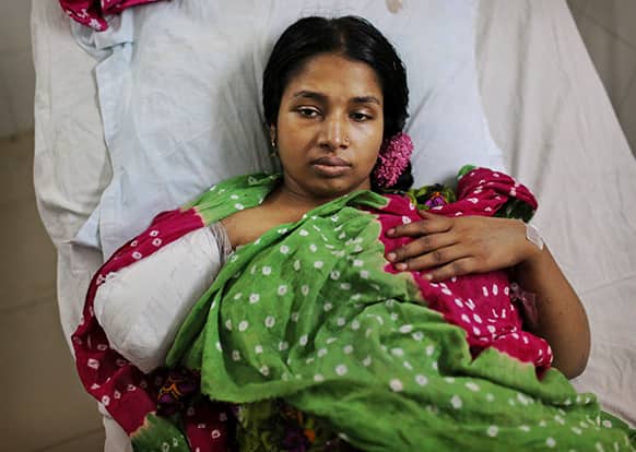A Bangladeshi garment worker who was rescued from a building that collapsed Wednesday lays in a hospital bed with an amputated arm sustained when she was trapped inside, in Savar, near Dhaka.