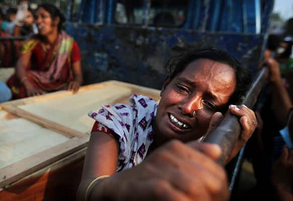 A Bangladeshi woman weeps as she sits next to the coffin of a relative who died in a building that collapsed Wednesday in Savar, near Dhaka.