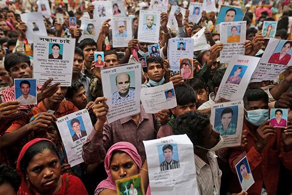 Bangladeshi relatives of missing workers in a building that collapsed Wednesday hold pictures of their family members in Savar, near Dhaka.