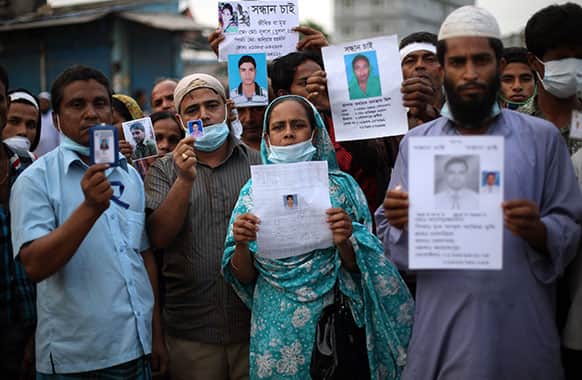 Relatives of missing victims gather holding photographs of their loved ones at the site of the garment factory building that collapsed Wednesday in Savar, near Dhaka.