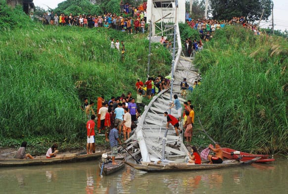 Thai villagers and rescuers look for survivors under the wreckage of a suspension bridge crossing the Pasak river after it collapsed, in Ayutthaya province, central Thailand.