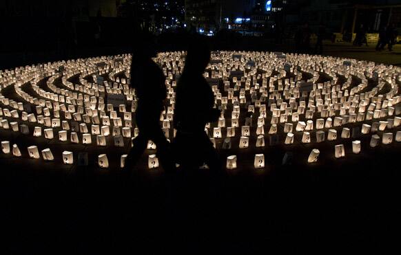 Visitors walk by a circle of lit candles to commemorate those who went missing during 1998-99 Kosovo war, in Pristina, Kosovo. International agencies estimated over a thousand people remain missing in Kosovo.