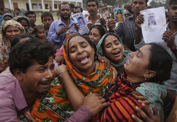 Bangladeshi relatives of garment worker Mohammed Abdullah cry as they as they arrive to collect his body at a makeshift morgue in a schoolyard near a building that collapsed Wednesday in Savar, near Dhaka, Bangladesh.