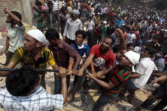 Bangladeshi rescuers work to pull down rubble at the site of a building that collapsed Wednesday in Savar, near Dhaka, Bangladesh.