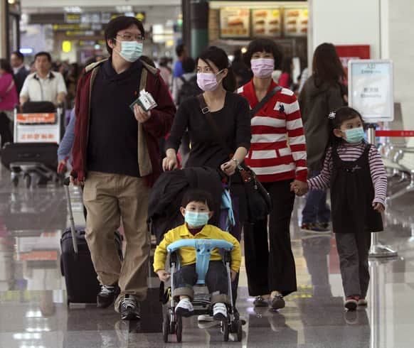 Tourists wear masks at the Songshan Airport in Taipei, Taiwan. Taiwan confirmed its first case of a new deadly strain of bird flu.