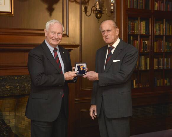 Prince Philip, the Duke of Edinburgh, right, receives the Order of Military Merit from Governor General David Johnston in Toronto.