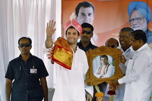 Ruling Congress party leader Rahul Gandhi, second left, waves to supporters after he was presented a traditional headgear during a campaign rally for the upcoming state elections in Tumkur, about 70 kilometers (43 miles) northwest of Bangalore.