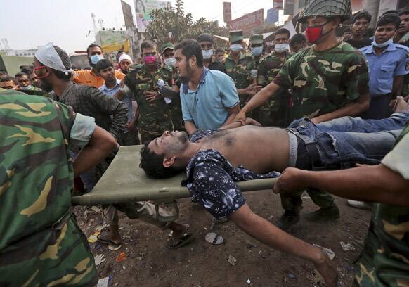 A Bangladeshi garment worker who was pulled alive from the rubble is rushed on a stretcher at the site of a building that collapsed Wednesday in Savar, near Dhaka, Bangladesh.