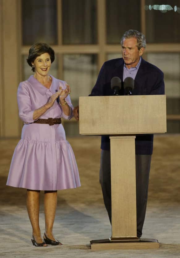 Former president George W. Bush, right, with former first lady Laura Bush, addresses the audience during the lighting of Freedom Hall ceremony at the George W. Bush Presidential Center, in Dallas.