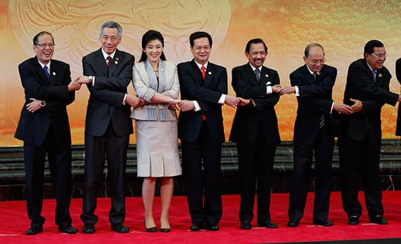 Philippines President Benigno Aquino III, Singapore PM Lee Hsien Loong, Thai PM Yingluck Shinawatra, Vietnamese PM Nguyen Tan Dung, Brunei Sultan Hassanal Bolkiah, Myanmar President Thein Sein, Cambodian PM Hun Sen join hands as they pose for a group photo at the 22nd ASEAN Summit