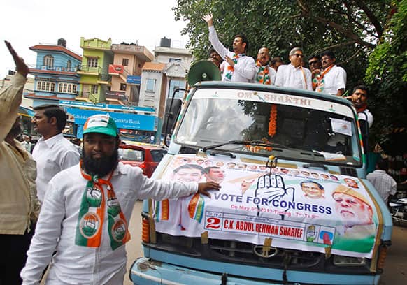 India`s ruling Congress party candidate Abdul Rahman Sharief, 29, one of the party`s youngest candidates, left on top of a truck, waves during a campaign rally for the upcoming state elections in Bangalore.