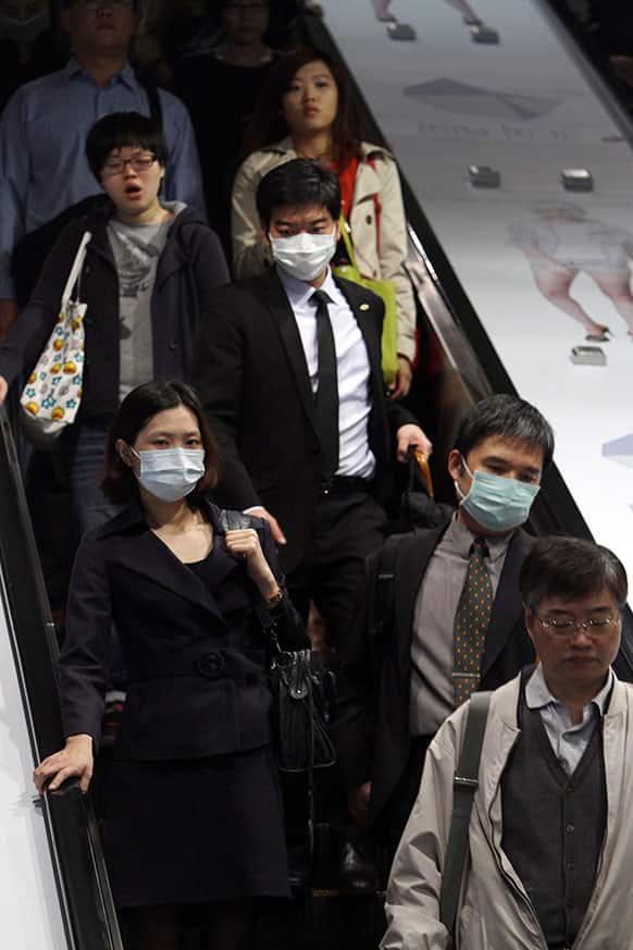 Commuters wear masks at a subway station in Taipei, Taiwan, Thursday, April 25, 2013. Taiwan has confirmed its first case of a new deadly strain of bird flu.
