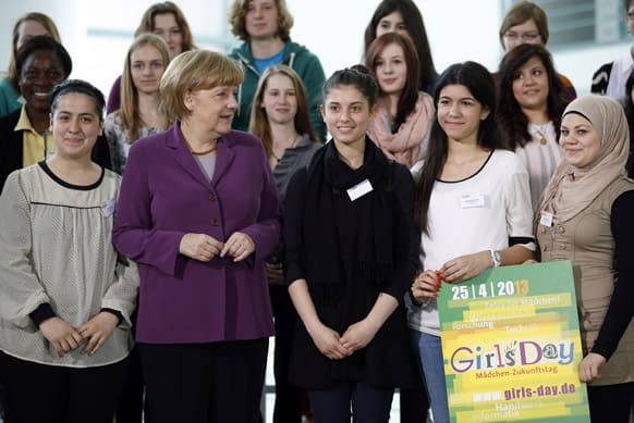 German Chancellor Angela Merkel poses with young students during a `Girls Day 2013` presentation event at the chancellery in Berlin, Germany.